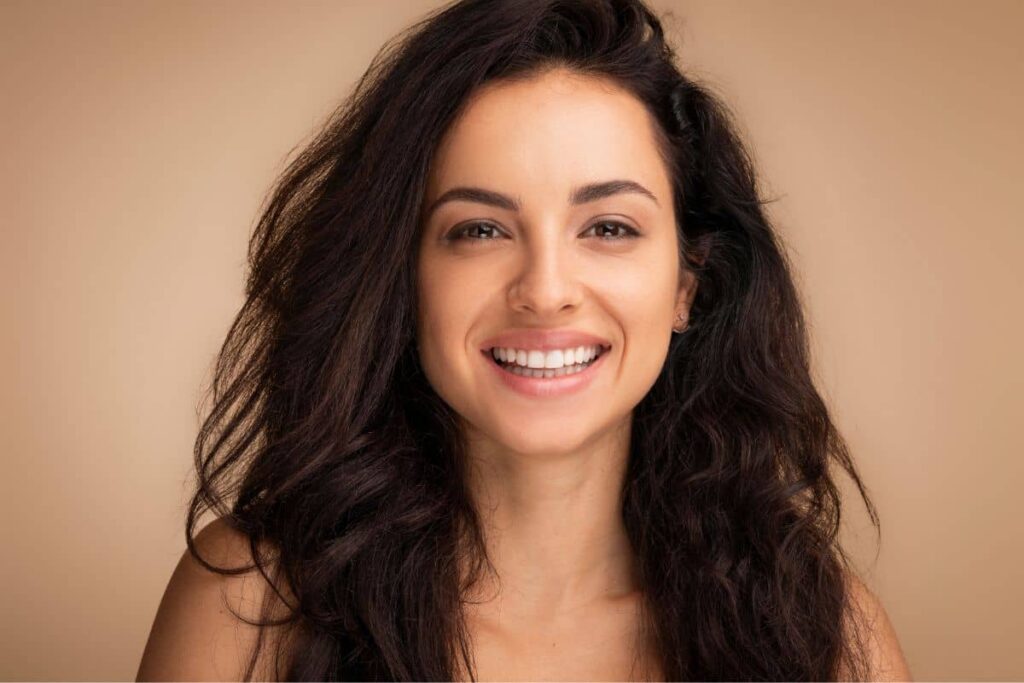 Smiling woman with youthful, radiant skin after a mini facelift for early facial rejuvenation.
